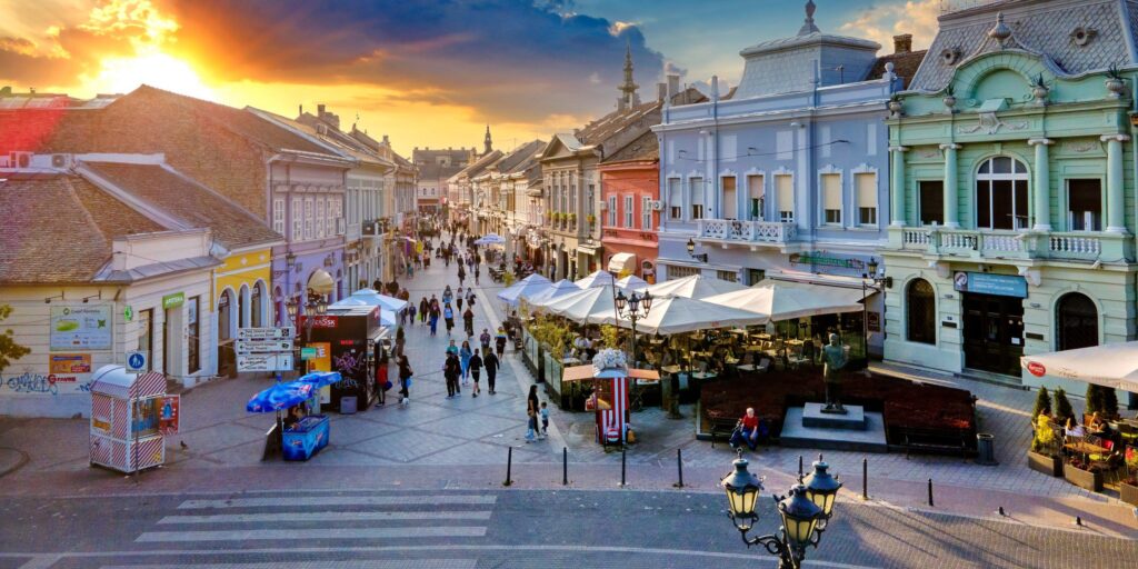Busy street in Novi Sad with cafés and pedestrians
